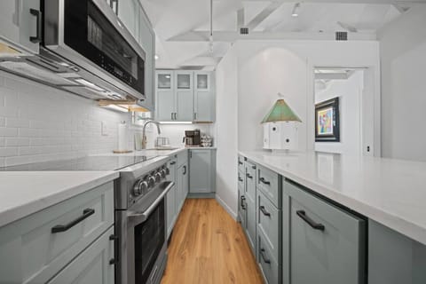 Modern updated kitchen featuring sleek stainless steel appliances, a spacious layout, and a stylish kitchen island with barstool dining—perfect for meals and gathering.