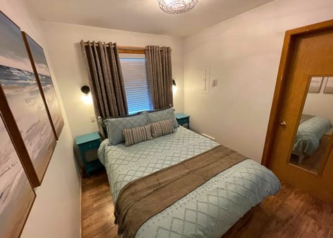 Ceil fan, window behind Queen bed with blackout shades. Walk-in closet to right.