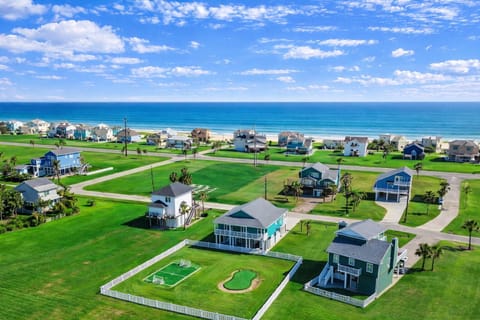 Aerial view of Galveston beach neighborhood showcasing proximity to the coast, private yard, and spacious vacation home layout.