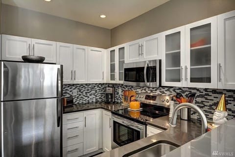 Gourmet kitchen with newer cabinets, quartz counters and Stainless-Steel appliances.