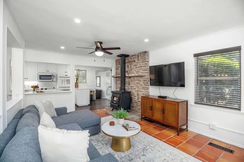 Indulge in luxury and comfort in our open concept living room, adorned with a plush sectional couch, cutting-edge flat screen TV, and curated designer elements.