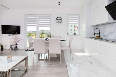 A dining area with a modern table and chairs, seamlessly connected to the living room and kitchen.
