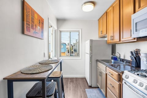 Kitchen - gas stove, microwave, fridge, blender, toaster, Keurig coffee maker, and coffee pods.