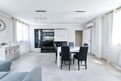 Zona Living con divano letto, mobile con Smart TV 55", tavolo da pranzo allungabile per 6 persone, climatizzatore Daikin