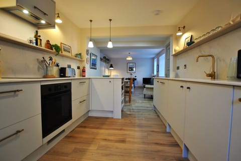 A fully fitted kitchen which leads to a dining area