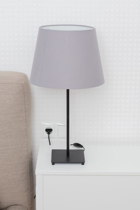 A close-up of a bedside lamp on a nightstand, adding a stylish and functional accent to the bedroom.
