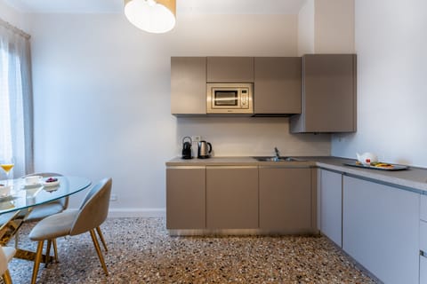 Deluxe Apartment | Private kitchen | Fridge, stovetop, electric kettle, dining tables