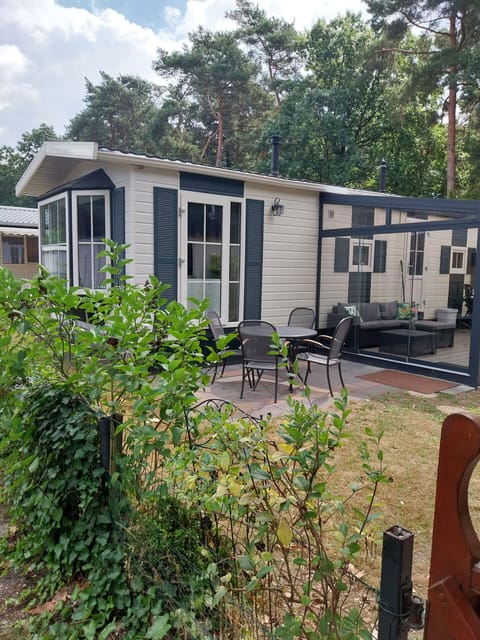 Het buitenaanzicht met tuinmeubels, een seirre en tuinhuisje van BPW 1105 Bospark 't Wolfsven - EEZZ