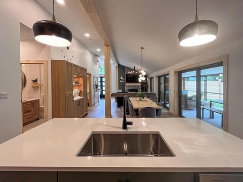 The kitchen island features a large sink, dishwasher, and seating for 4 with usb charging.