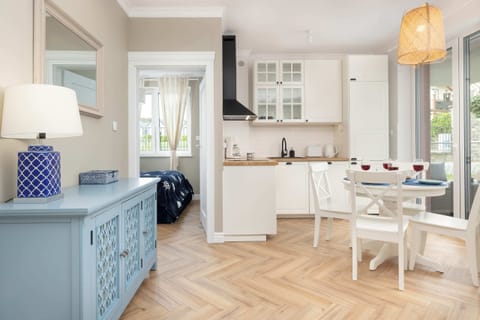 A dining space with a round table, bright white cabinets, and a touch of blue decor.

