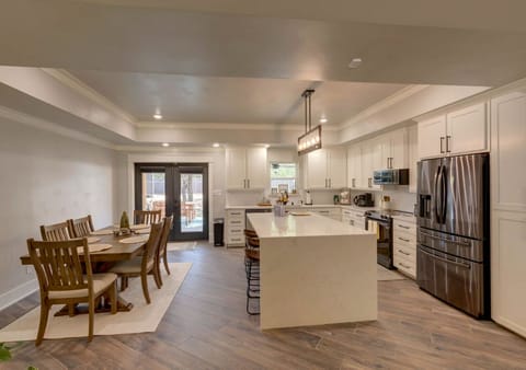 Kitchen with marble island, white cabinets, stainless appliances
