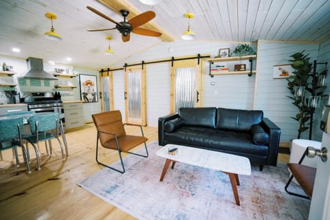 Open concept living, kitchen and dining room with comfy couch and retro table