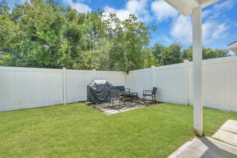 Peaceful backyard with patio seating and gas grill