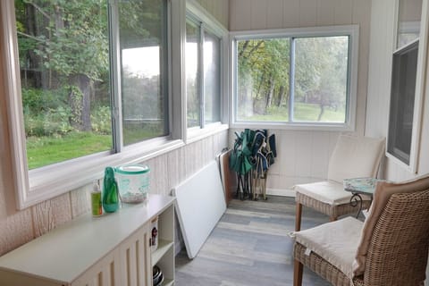 Get the sense of being surrounded by nature without the bugs on this enclosed back porch.