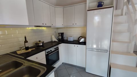 Inside kitchen with ceramic hob also  showing stairs  to mezzanine 