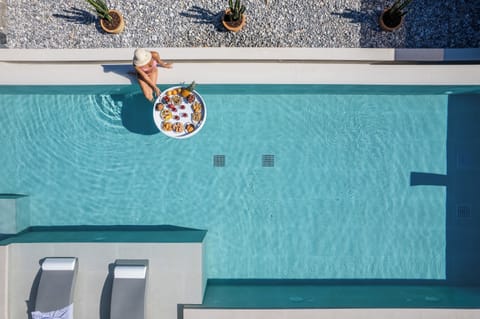 A private, 56 sq.m. swimming pool, adorned with a graceful waterfall and two in-pool chaise longues