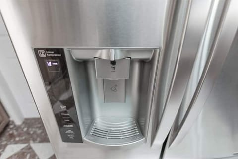 The LG stainless steel fridge has a built-in water dispenser.
