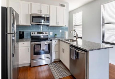 Fully equipped kitchen with stainless steel appliances (microwave, dishwasher, stove, fridge)