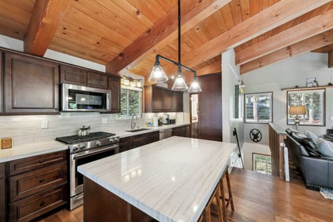 Bright, welcoming kitchen with wood beams, modern appliances, and a cozy island—perfect for cooking, gathering, and sharing meals.