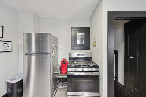 Coffee-making supplies, full-size refrigerator, and cooking stove.