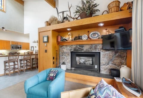 Rustic living space with a stone fireplace and warm mountain-inspired decor.