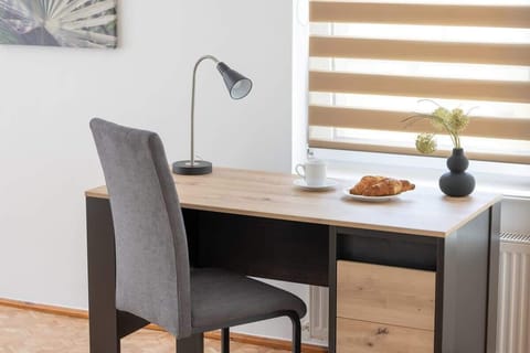 Functional workspace with a desk and chair, accented by a small plant for a touch of greenery.