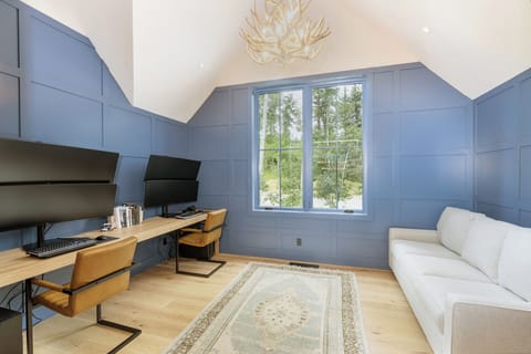 A versatile game and office room with an ensuite full bathroom, Queen pull-out couch, and multiple monitors—perfect for work, play, and hosting guests.
