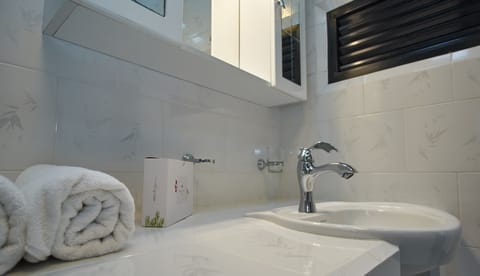 Elite Studio Suite | Bathroom | Rainfall showerhead, towels, soap, toilet paper