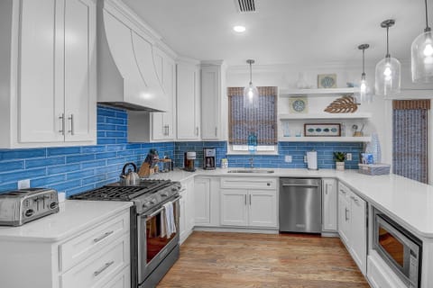 Gourmet Kitchen-Step into our updated gourmet kitchen, bathed in natural light and fully stocked with vacation essentials. Stainless steel appliances amidst the modern design, while a spacious pantry ensures your culinary needs are met during your stay.