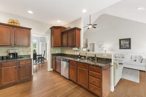 Spacious and functional granite countertops and a dishwasher.