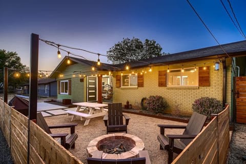 Cozy backyard retreat with string lights, a fire pit, and comfortable seating.