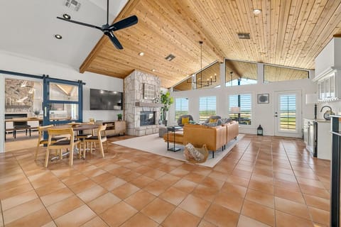 This living room offers a seating area, TV, small breakfast table, the kitchen. Doors lead to the primary bedroom and grand living room.