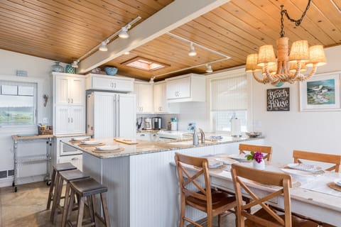 The kitchen features modern appliances and a large island with counter-top seating.