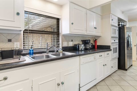 Those striking white cabinets are filled with cookware, dining ware, utensils, and glasses for you to use, too!
