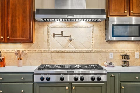 Fully stocked kitchen featuring stainless steel appliances, and quartz countertops, including a dishwasher, microwave, gas cooktop, and double ovens