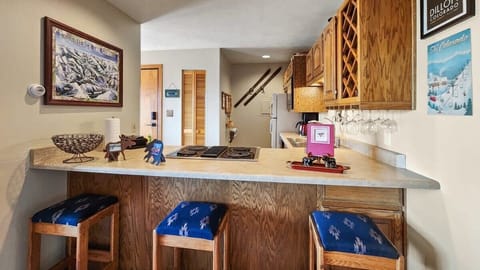 The view into the kitchen from over the kitchen bar where you will find 3 bar stools providing additional seating.