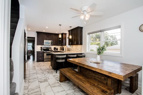  The bright kitchen offers a beautiful, large wooden table and counter seating