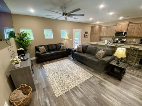 Entry level living area with 2 full size couches, a 75" HD Smart TV, & Local Cable, near the kitchen & dining area.