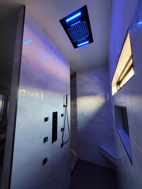 Master bathroom shower with remote controlled LED/bluetooth rain shower head