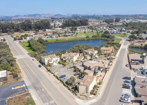 Breathtaking aerial view of the nearby park and peaceful pond, framed by the coastal breeze and laid-back beach vibe of the area.