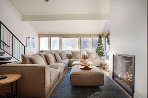 Oversized Living Room couch with fireplace and views of mountain and lift