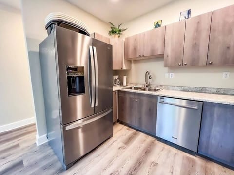 Side by side refrigerator with water dispenser and freezer below, and a chrome dishwasher