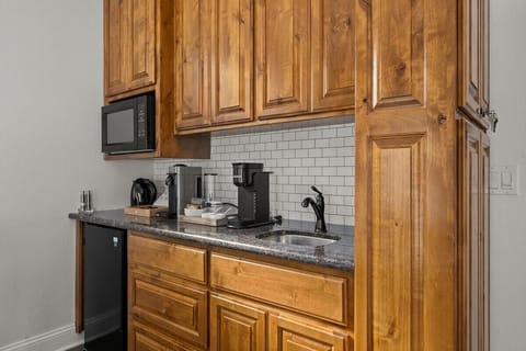 Kitchenette complete with bar sink, microwave, mini fridge, and coffee/tea bar