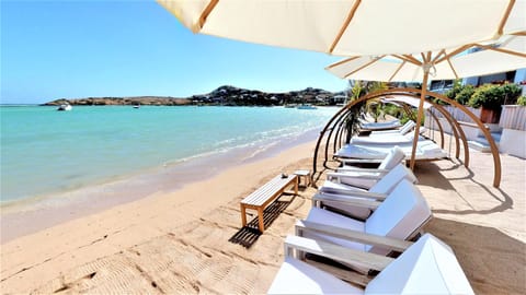 On the beach, white sand, sun loungers, beach towels