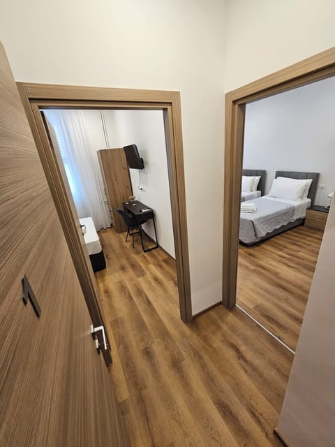 Comfort Triple Room, Private Bathroom | Desk, laptop workspace, blackout drapes, iron/ironing board