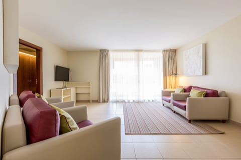 Deluxe Suite, 2 Bedrooms | Living room | 50-cm TV with satellite channels