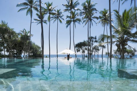 Outdoor pool, an infinity pool, pool umbrellas, sun loungers