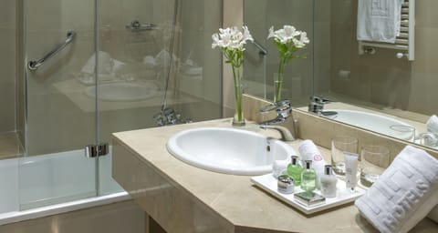 Deep soaking tub, rainfall showerhead, eco-friendly toiletries