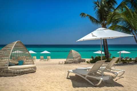 On the beach, white sand, sun loungers, beach towels