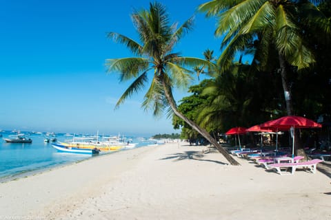 On the beach, white sand, sun loungers, beach umbrellas